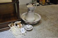 Wide view of antique wash basin set with pitcher, soap dish, and two Prochain dolls on the floor.