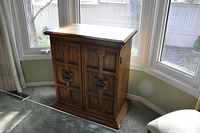 Heritage wooden bar unit closed, showing carved front doors and metal handles with lock.