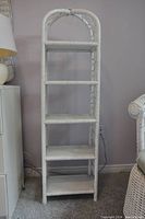 White rattan arched shelf with 5 shelves, simple design, no decorations.