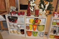 Two white shelving units containing various decorative and storage items in a basement environment.