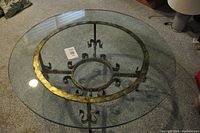 Round glass coffee table showing the circular clear glass top with a metal decorative ring beneath.