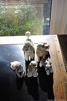 Five dog figurines arranged on a table in natural light showing overall condition and detail.