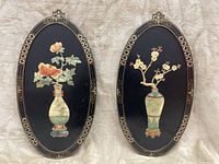 Front view of pair of oval Chinese wood art panels with floral 3D designs in vases