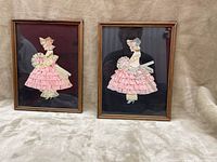 Photo showing both framed ribbon bridesmaid figures side by side on a beige fabric background, highlighting overall appearance and frame style.