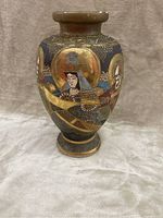 Front and side view of Japanese Satsuma vase showing hand-painted figures with gold halos and traditional attire on dark blue background.