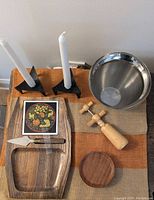 Full lot showing cheese board, cheese cutter, WMF ice bucket, black iron candle holders with white candles, wooden corkscrew, and wooden coasters