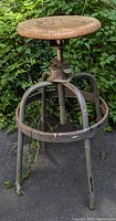 Front view of the mid century industrial adjustable stool showing wooden seat and metal frame with circular footrest.