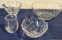 Photo showing three crystal items on a dark fabric: a small lute-patterned Orrefors vase, a petal-shaped Orrefors bowl, and a clear rounded textured Reims France bubble ridge bowl