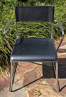 Front view of black faux leather and chrome directors chair showing condition of seat and frame.