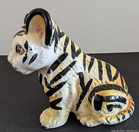 Left side view of the ceramic tiger cub showing sculpted details and painted stripes and colors