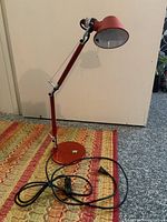 Full view of the lamp on floor showing base, arm, shade and cord