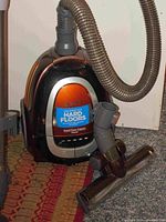 Photo showing Bissell vacuum cleaner with flexible hose and hard floor attachment labeled 'Designed for Hard Floors'