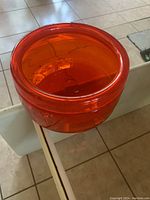 Red glass bowl shown from a top-front angle highlighting the round shape and thickness of the glass.