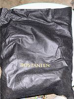 Black dust bag with gold Bostanten logo on front