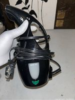 Front angle shot showing power plug, water level window with max fill, and wrapped cord.