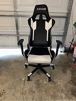 Front view showing full chair with black and white upholstery and 'S-RACER' branding on headrest.