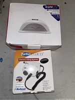 Boxed SunUV LED nail lamp and TurboFilet electric filing system showing product packaging.