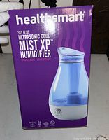 Boxed HealthSmart Mist XP Ultrasonic Cool Mist Humidifier in purple packaging featuring product image and specifications.