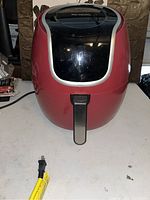 Front view of red Power XL air fryer closed, showing the black top panel and front handle.
