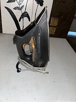 Side profile of Rowenta Steamium iron showing the ergonomic handle and power cord wrapped around it.