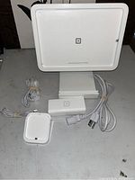 Front view of Square touchscreen merchant display with cables and accessories on table