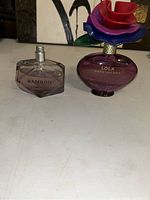 Photo of two Marc Jacobs women's perfume bottles: Bamboo without cap, Lola with floral decorative cap