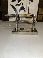 Desk set showing magnifying glass and letter opener with horn-colored handles on metal base, front view