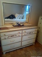 Photo of white dresser with 6 drawers and an attached/detachable mirror above. Decorated with gold floral patterns and gold hardware.