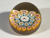 Top view showing the colorful millefiori floral design inside the clear glass paperweight