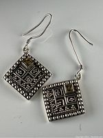 Pair of sterling silver dangle earrings with square pendants and decorative beaded edges, each containing a small square crystal near the top corner, displayed on white background.