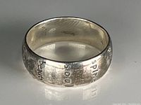 Close-up photo of sterling silver ring showing engraved words 'spirit' and 'faith' along with the textured silver finish.