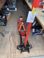Photo showing one 3 ton hydraulic floor jack and two 6 ton jack stands placed on a wood floor.