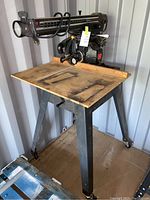 Full front and side view of Craftsman 10 inch radial arm saw mounted on metal stand, showing saw blade, table, and arm scale