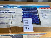 Top and front of the boxed Mastercraft 47 Bin Storage Rack showing brand, item name and assembly illustration with bins and shelves.