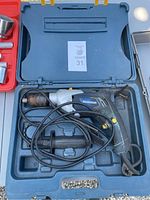 Mastercraft hammer drill inside a blue plastic carrying case with molded sections for holding the drill and accessories.