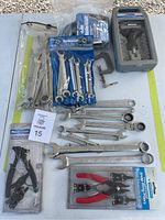 Overall view of wrenches, clamps, pliers and packaged tools arranged on a surface