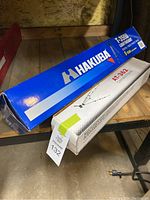 Boxes of the two tripods, Hakuba T-3500 in blue box and AT-362 in white box