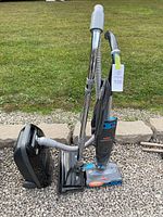 Bissell SteamVac and Kenmore vacuum on gravel, showing physical condition and setup.