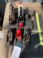 Top view of all 7 wood planers arranged on a wooden surface, shows general condition and variety.