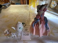 Photo of Royal Doulton figurine, Belleek teapot, Swarovski bear, and crystal elephant with lot number 108.