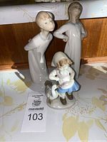 Full view of the three Lladro figurines showing the girl with goose and two standing female figures.