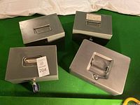 Four metal cash boxes with two keys attached on locks.
