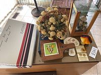 Wide view of the lot showing terrarium, Fitz and Floyd dish, mushroom candles, patches and other mushroom decor items on a glass table.