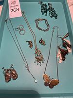 Full collection of necklaces, earrings, bracelet laid out on aqua tray including Swarovski and Sherman labeled.