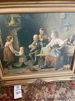 Close-up of framed print showing detailed depiction of family scene with dancing child and musicians