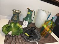 Photo showing entire lot of decorative items including vases, bowl, pitcher, and covered dish on table.