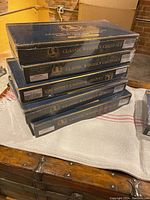 Six black boxes of Classic Wooden Chess Sets stacked, showing unopened packaging.