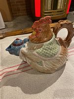 Side view of Fitz & Floyd ceramic teapot shaped like a chicken with colorful hand-painted details.
