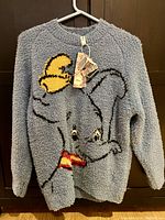 Full view of the Dumbo sweater showing the front character design and the texture of the material.