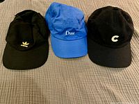 Front view showing three hats: blue Dime, black Coal logo, black Adidas gold logo